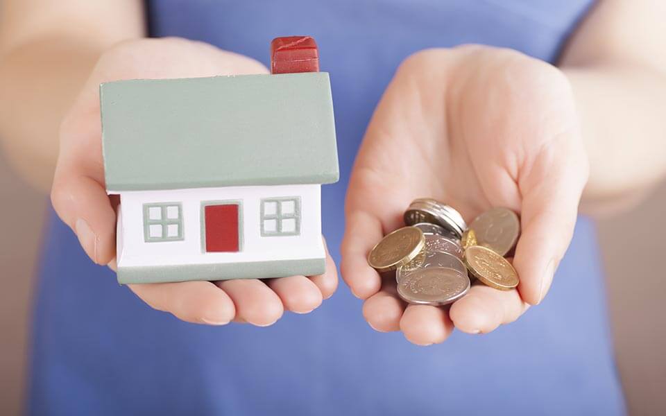 Toy house and money in a womans hand