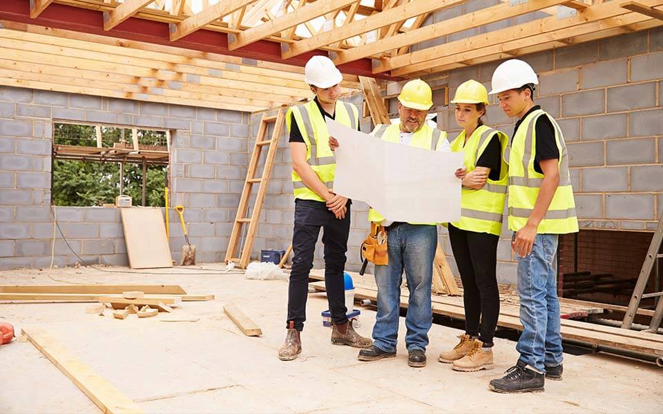 People reading blueprints on building site