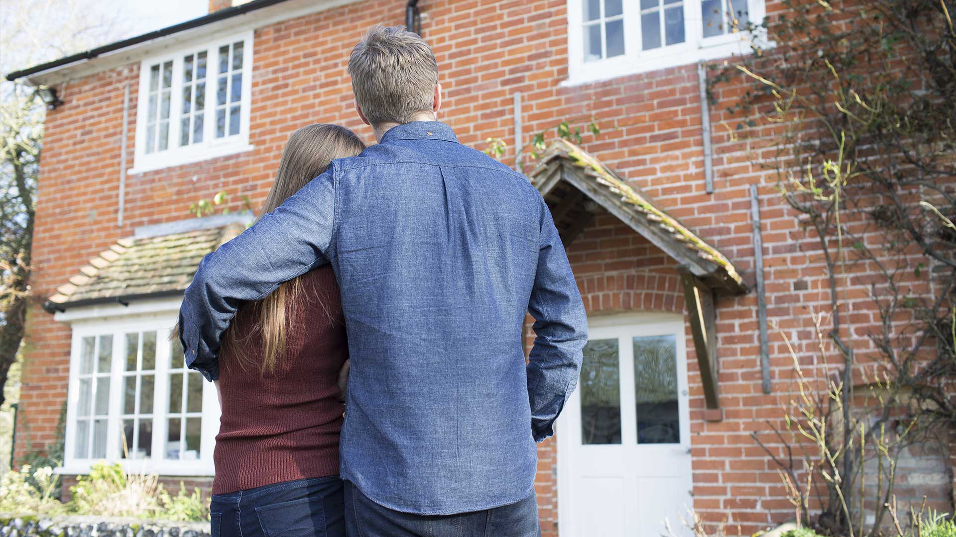 Couple standing outside house