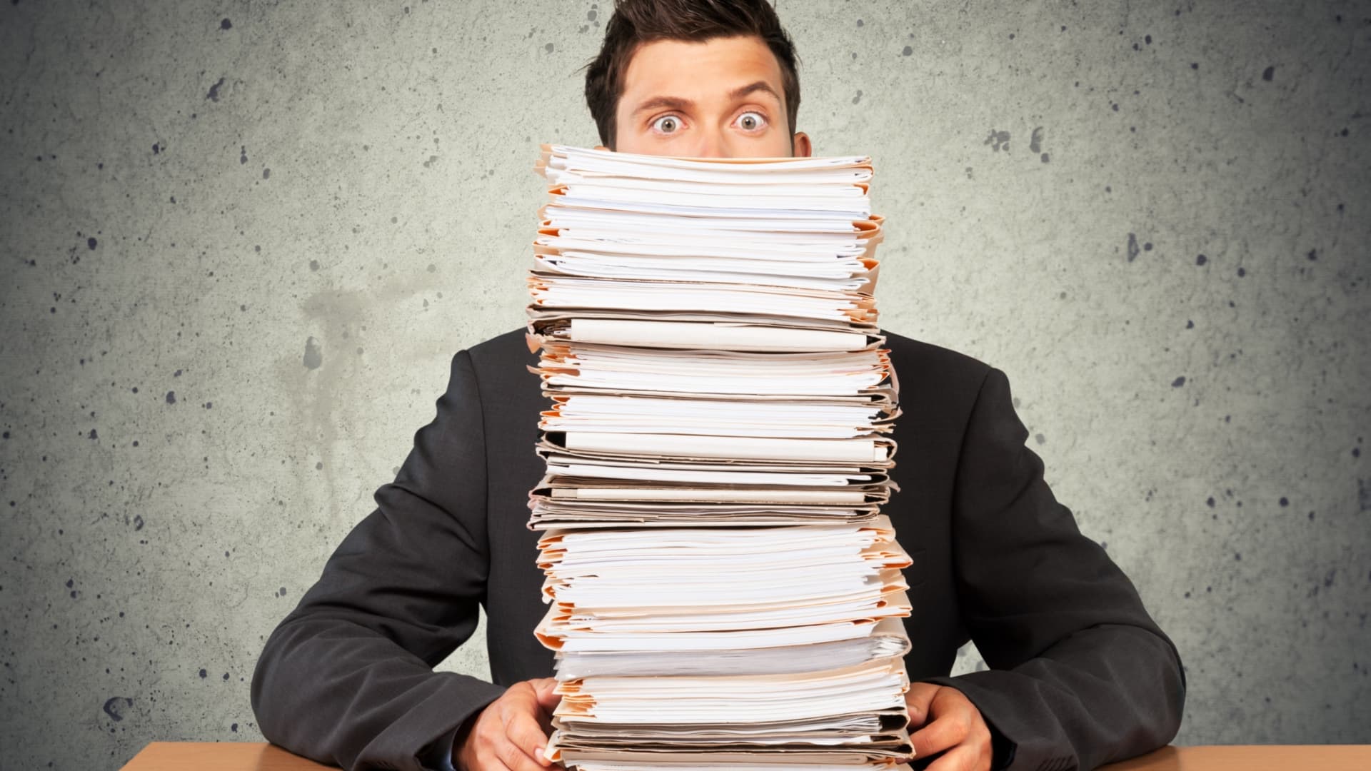 Person behind stacks of paperwork