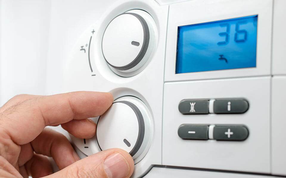 hand turning up a thermostat